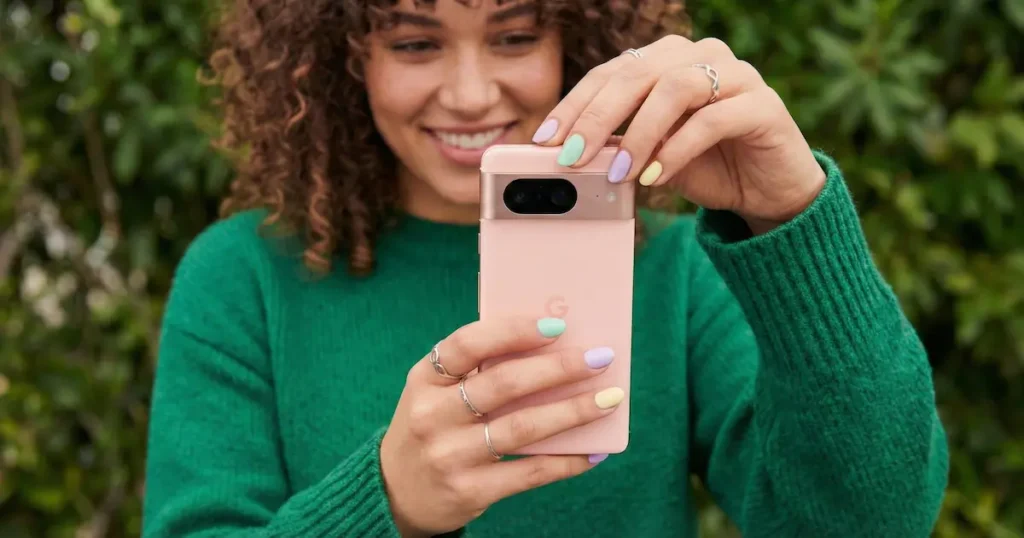 Google Pixel 9a en color rosa capturando una foto en exterior, mostrando el diseño trasero y la cámara principal en una escena real.